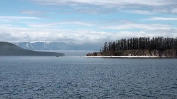 Vågor på vattenytan på bakgrunden av mörk himmel och grå moln vid solnedgången. — Stockvideo