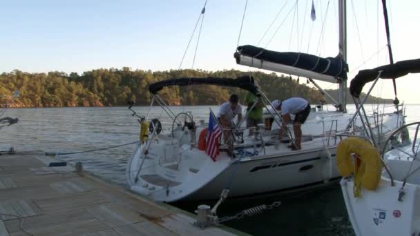 Menschen segeln auf weißer Jacht vor Bergküste in der Türkei. — Stockvideo