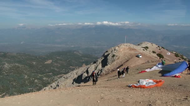Mensen bereiden zich voor om te vliegen op een paraglider op de Babadag berg in Turkije. — Stockvideo