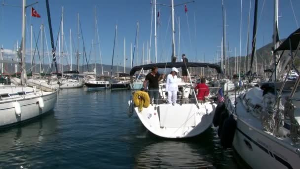 Meisje in witte kleren met mannen op jacht in de haven van plezier boten en ambacht. — Stockvideo