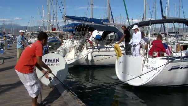 Les gens sur le yacht dans le port de bateaux de plaisance et d'embarcation . — Video
