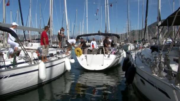 Människor på yacht i hamnen för fritidsbåtar och hantverk. — Stockvideo