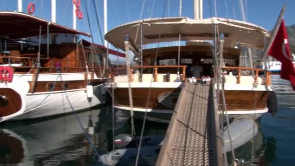 Luksusowe jachty spokojnie stoją na tle błękitnego nieba w porcie Turcji. — Wideo stockowe