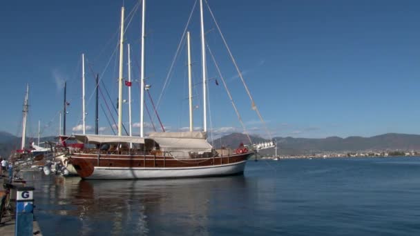 Luxe jachten rustig staan op de achtergrond van de blauwe lucht in de haven van Turkije. — Stockvideo