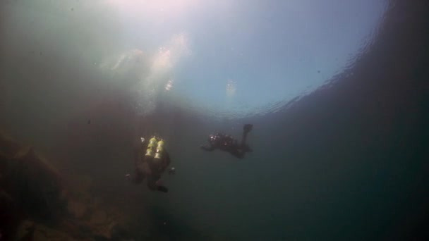 Duikers met camerashoot onderwater video van boot op Baikal. — Stockvideo