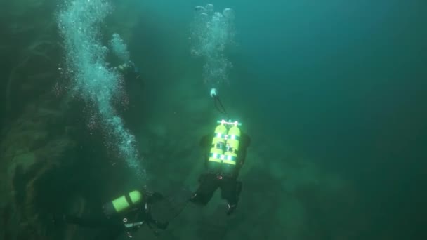 바 이 칼 호수깊은 곳에서 수영하고 있는 카메라를 든 스쿠버 다이버들. — 비디오