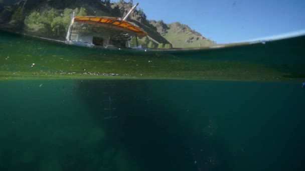 Unterwasseraufnahmen eines Tauchers, der von einem Boot auf dem Baikal ins Wasser springt. — Stockvideo