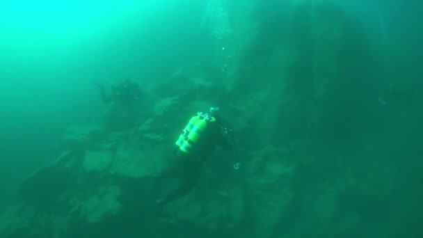 在贝加尔湖深水底游泳的一组带摄像头的潜水者. — 图库视频影像