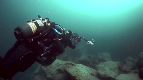 Caméramans plongeur sur fond de réflexion de la lumière du soleil dans le lac Baïkal . — Video