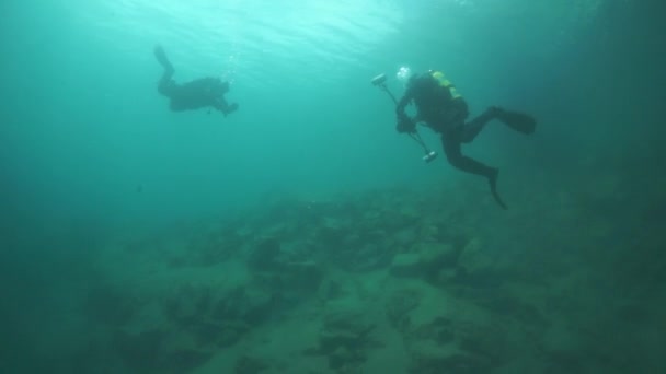 Dykare kameramän simmar djupt under vattnet i sjön Baikal. — Stockvideo