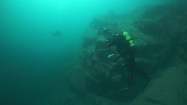 Cameramenscuba duiker onder water in het Baikalmeer. — Stockvideo