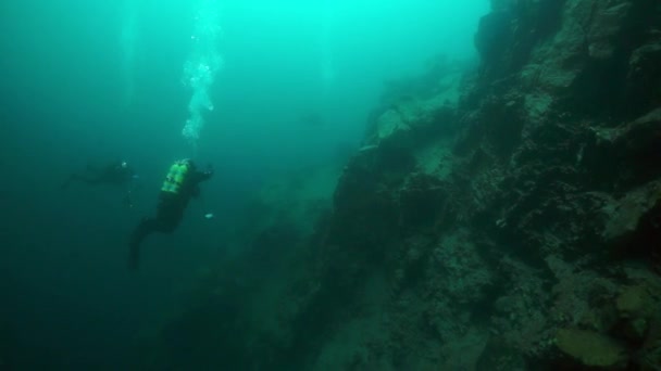 Scuba diver cameramen with group swimming deep underwater in Lake Baikal. — Stock Video