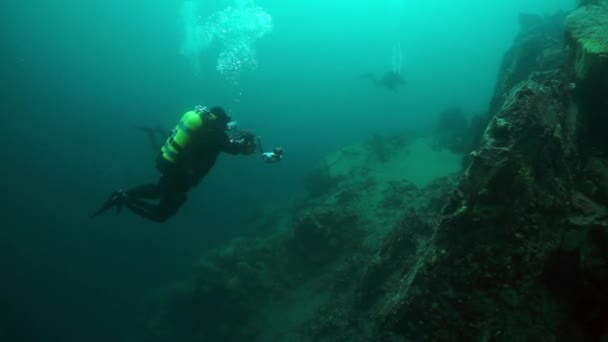 Cameramenscuba duiker met groep onder water in het Baikalmeer. — Stockvideo
