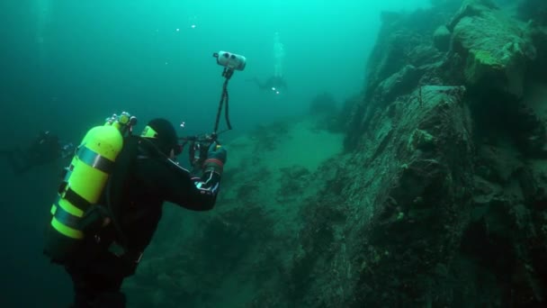 Buceador de camarógrafos con grupo bajo el agua en el lago Baikal . — Vídeo de stock