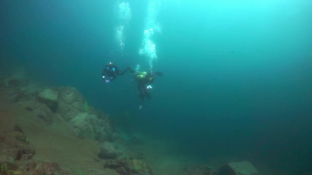 Caméramans plongeur sur fond de réflexion de la lumière du soleil dans le lac Baïkal . — Video