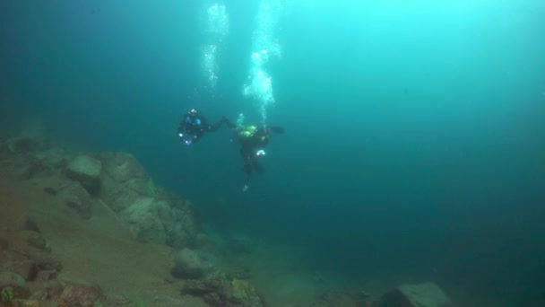 Taucher-Kameramänner vor dem Hintergrund der Reflexion des Sonnenlichts im Baikalsee. — Stockvideo