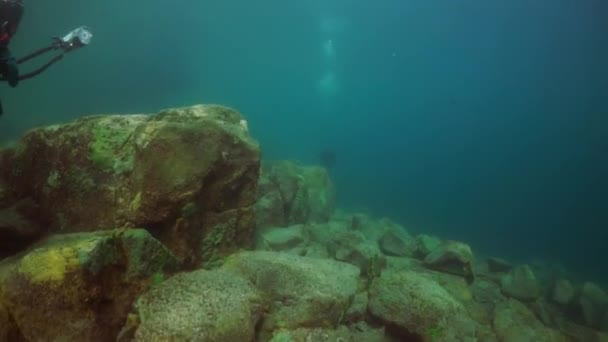 Taucher mit Kamera schwimmt tief unter Wasser im Baikalsee. — Stockvideo