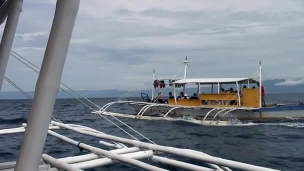 People ride on philippine boat with bamboo wings in sea in Philippines. — Stock Video