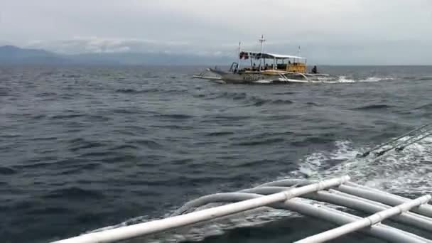 Οι άνθρωποι οδηγούν σε πλοίο Philippine με φτερά μπαμπού στη θάλασσα στις Φιλιππίνες. — Αρχείο Βίντεο