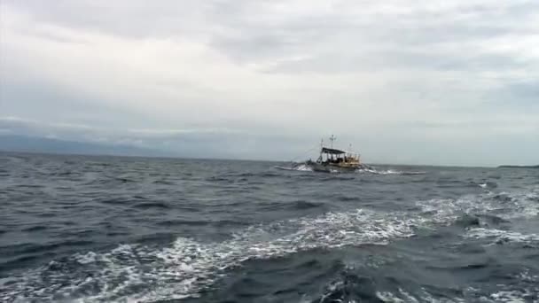 Mensen rijden op Filippijnse fillippijnse boot met bamboe vleugels in zee in Filippijnen. — Stockvideo