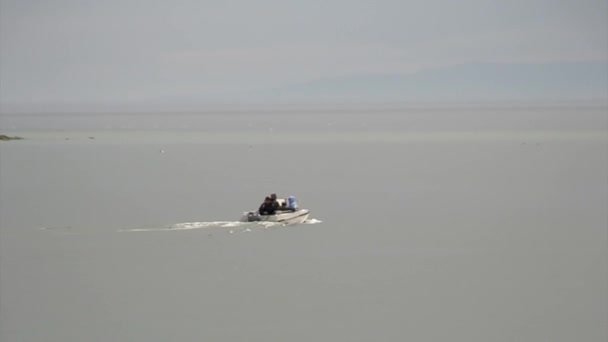 Barco a motor sobre un fondo de horizonte gris y superficie de agua en el lago Baikal . — Vídeos de Stock