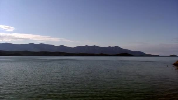 Bergslandskap med gröna träd på bakgrunden av stenig kust. — Stockvideo