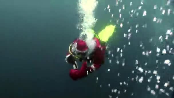 Onderwater Santa Claus duiker zwemt in waterbellen in Nieuwjaar. — Stockvideo