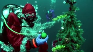 Suyun altındaki Noel Baba dalgıcı yeni yılda bir Noel ağacını süslüyor..