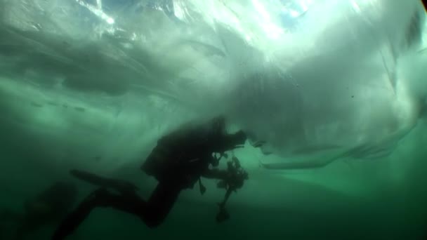 Tauchen unter dem Eis des Kameramanns Unterwassertaucher im kalten Wasser des Baikalsees. — Stockvideo