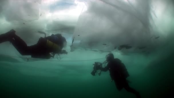 Potápění s podvodní kameraman pod ledem ve studené vodě jezera Bajkal. — Stock video