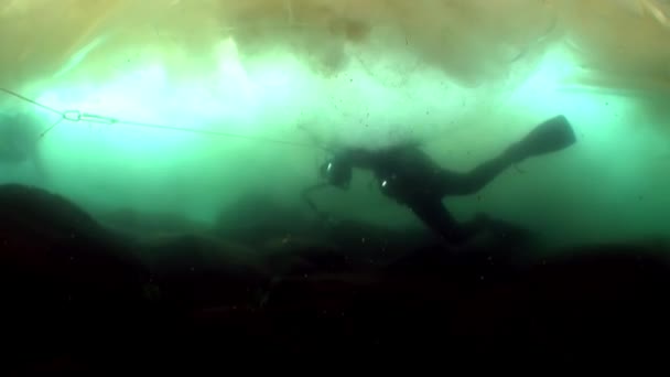 Vídeo subaquático filmando sob gelo em água fria de pessoas na superfície do gelo . — Vídeo de Stock