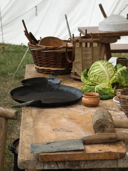 Casseroles noires, salade et couteau sur table en bois — Photo