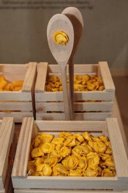 Tortellini makarna çeşitleri ahşap kutusunda kahverengi kepçe ile