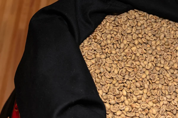 Primer plano de granos de café amarillo bronceado dentro del saco negro —  Fotos de Stock