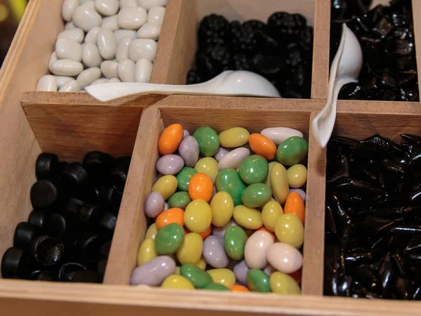 Kolorowe różne cukrem migdałów w drewniane pudełko — Zdjęcie stockowe