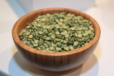 Ahşap kase içinde bölünmüş yeşil bezelye