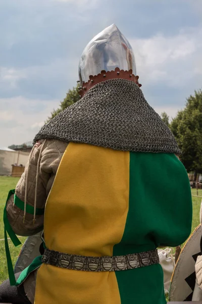Ritter mit Helm und gelb-grüner Kleidung auf einem Chai sitzend — Stockfoto