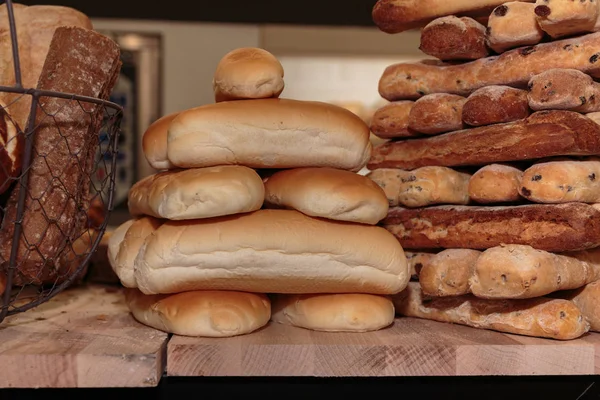 パン ロール品揃えと木の板の上にフランス パンのヒープ — ストック写真