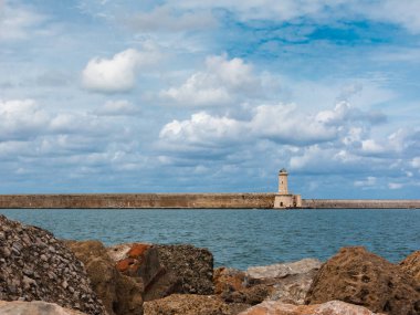 Tuscany kıyı şeridi: Beyaz fener kulesi, uçurumlar ve taş Jett