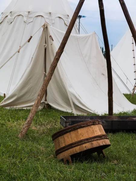 Tahta kova devrik beyaz çadır yakınındaki çayır üzerinde
