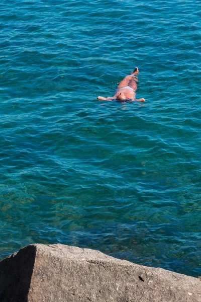 Hombre jugando a Dead Man Position en el mar cerca de Stone Rock — Foto de Stock