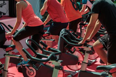 Erkek ve kız spor salonunda Grup: egzersiz bisikletleri iplik ile