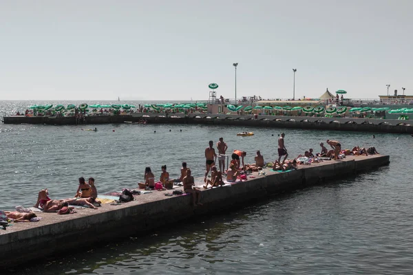 Multitud de gente en el arrecife cerca del mar en verano en Livorno, Ital — Foto de Stock
