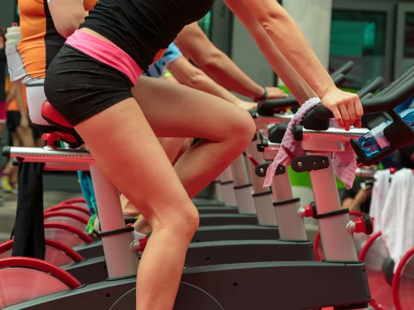 남자와 체육관에서 여자의 그룹: 회전 하는 자전거와 운동 — 스톡 사진