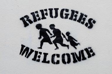 Beyaz duvar üzerine hoş geldiniz mülteciler metin şablon baskı