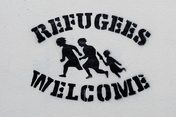 Welcome Refugees Text Stencil Print on White Wall