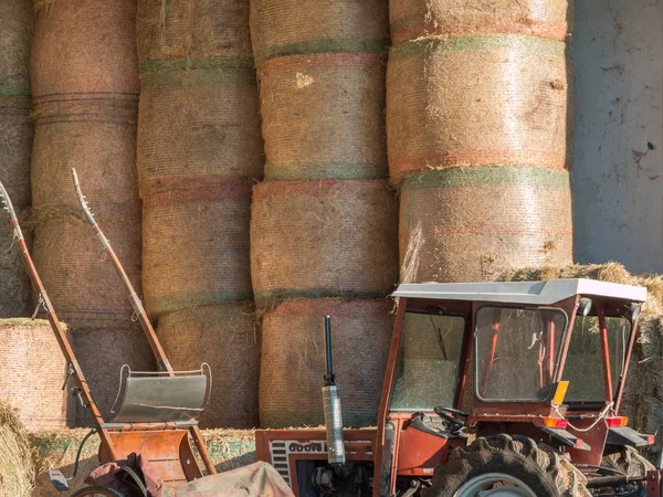 Runda buntar av höstackar och traktorn på plats på landsbygden — Stockfoto