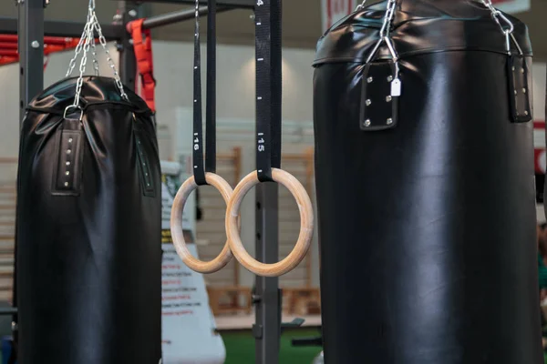 Schwarzer Boxsack und Crossfit-Fitnessringe: Trainingsgeräte — Stockfoto