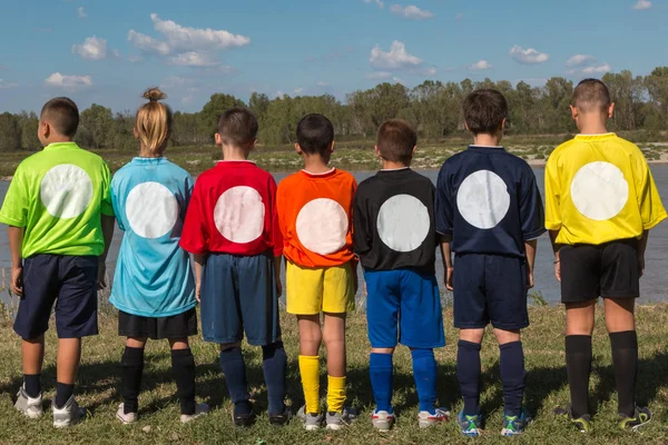 Dzieci w linii plecami z koszulki o różnych kolorach — Zdjęcie stockowe