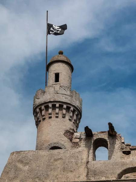 Starověký věž s pirátskou vlajkou v zámku v Itálii, Evropa — Stock fotografie